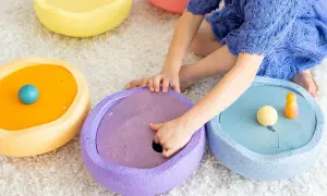 Kind spielt mit bunten Stapelsteinen und erforscht verschiedene Stapelsteine Spielideen.