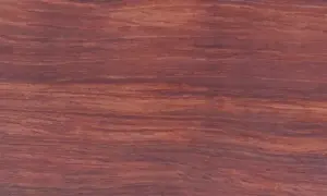 Textura rica y veteada de madera bubinga, con tonos rojizos y marrones que evocan la calidez de la naturaleza.