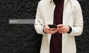 Mężczyzna z telefonem szuka w sieci informacji, jak włączyć Google Discover.