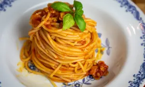 En portion spaghetti med en smakrik tomatsås, perfekt för ett enkelt pasta pomodoro recept. Garnerad med färsk basilika.