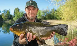 Glücklicher Angler präsentiert stolz seinen Fang: einen stattlichen Fisch, der beim Maifisch angeln an Land gezogen wurde.