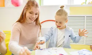 Uśmiechnięci rodzice z dzieckiem malują palcami. Radosna zabawa i kreatywność w kolorowym pokoju.