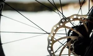 Zbliżenie na tarczę hamulcową roweru, która po zimie zaczyna piszczeć.