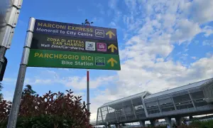 Znaki kierunkowe na lotnisku Bolonia: Marconi Express, Car Sharing i Bike Station.