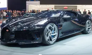 Lśniący, czarny Bugatti La Voiture Noire na wystawie, otoczony tłumem widzów.