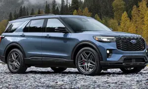 Niebieski Ford Explorer ST na kamienistej plaży, z jesiennym lasem w tle.