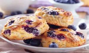 Färska blåbärsscones med smält smör, redo att avnjutas.