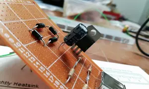 Układ elektroniczny na płytce stykowej z diodami, rezystorami i kondensatorem. Widać też element przypominający warystor.