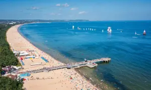 Brzeźno atrakcje: tłumy na plaży, molo, żaglówki i statki na morzu. Idealne miejsce na letni wypoczynek.