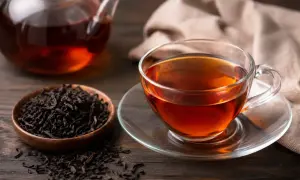 Aromatic black tea w filiżance i dzbanku. Czy herbata ma kofeinę? Tak, czarna herbata zawiera kofeinę, która pobudza.