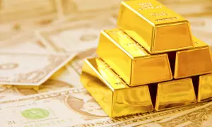 Złote sztabki ułożone na dolarach symbolizują globalne rezerwy złota i bogactwo.