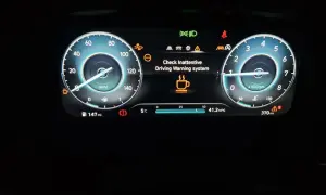 Panel de Hyundai i20 con fallo: "Check Inattentive Driving Warning system" y taza de café.