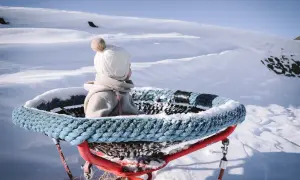 Kleines Kind im Schnee, bereit für den Winterurlaub mit Baby. Die Aussicht ist atemberaubend.