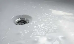 Acqua che scorre nello scarico della doccia, un segno che la pulizia è stata efficace.