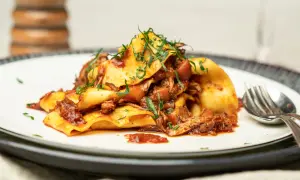 Herzhaftes Pasta Ragu mit breiten Nudeln, übergossen mit einer reichhaltigen Fleischsauce und garniert mit frischen Kräutern.