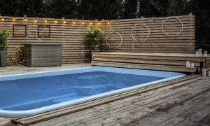 En avkopplande oas med en pool omgiven av en vacker trall. Ljusslingor och dekorationer skapar en mysig atmosfär.