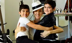 Celine Dion z dwoma synami, którzy ją obejmują. W tle gitary i figurki Michaela Jacksona.