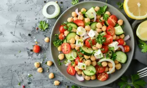 Ensalada de garbanzos de bote con tomate, pepino, queso feta y cebolla morada. Fresca y colorida, perfecta para un día caluroso.