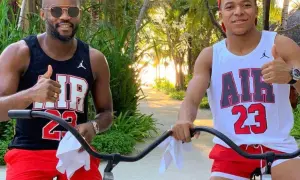 Brat Kyliana Mbappé, Ethan, w czarnej koszulce i czerwonych spodenkach, pozuje do zdjęcia z bratem, Kylianem, w białej koszulce i czerwonych spodenkach.
