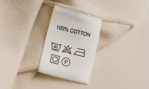 Metka z 100% bawełny. Zawiera skróty tkanin i symbole pielęgnacji: pranie w 40°C, zakaz wybielania, prasowanie, suszenie w suszarce i czyszczenie chemiczne.