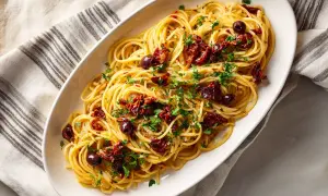 Spaghetti puttanesca, en smakrik rätt med soltorkade tomater, oliver och persilja.