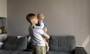 Starszy brat opiekuje się siostrą. Zastanawiasz się, od jakiego wieku dziecko może zostać samo w domu?