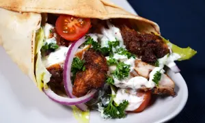 En saftig kyckling shawarma i pitabröd med tomater, lök, sallad och vit sås.