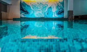 Nowe baseny w Poznaniu zachwycają nowoczesnym designem i artystyczną mozaiką na ścianie. Idealne miejsce na relaks.