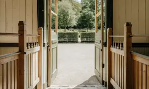 Öppna dörrar leder ut till en trädgård med en vacker grind och ett staket.