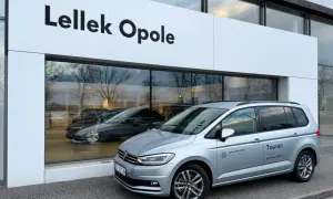 Srebrny Volkswagen Touran przed salonem Lellek Opole.