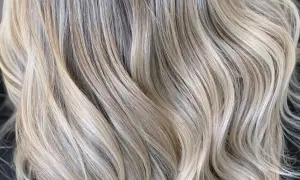 Falujące pasma włosów w odcieniach ciepły blond i jasnego beżu, tworzące subtelne refleksy.