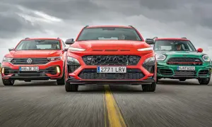 Trzy sportowe małe SUV-y: czerwony Volkswagen, pomarańczowy Hyundai i zielony Mini, jadące po drodze.