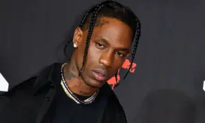 Travis Scott w czarnej koszuli i naszyjnikach, z warkoczami. Fani w Polsce czekają na jego koncert.