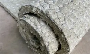 Gerolltes Dämmmaterial mit Drahtgeflecht. Um asbest erkennen zu können, ist Vorsicht geboten, da es sich um ein gesundheitsschädliches Material handelt.