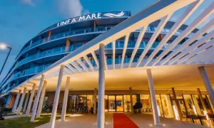Nowoczesny hotel Infa Mare z charakterystycznym zadaszeniem i czerwonym dywanem zaprasza do swojego wnętrza.