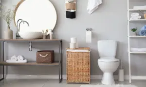Bagno moderno con lavabo, specchio, cesto in vimini e rotolo di carta igienica. L'altezza porta rotolo carta igienica è ben visibile.