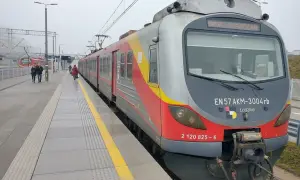 Pociąg EN57 AKM-3004rb z napisem "WARSZAWA" na stacji. Sprawdź rozkład jazdy Nowy Dwór Mazowiecki, aby zaplanować podróż.