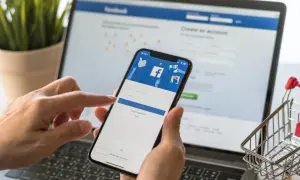Ręce trzymające smartfon z ekranem logowania Facebooka. Dowiedz się, jak dodać email na FB, aby ułatwić sobie dostęp.