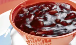 Gęsty, ciemny kisiel z owocami w pomarańczowej miseczce. Czy kisiel jest dobry na jelita? Może być, jeśli jest domowy i z naturalnych składników.