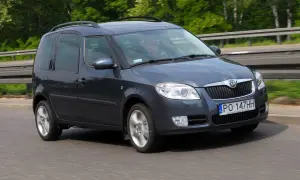 Ciemnoszara Skoda Roomster jedzie po drodze, za kierownicą siedzi mężczyzna.
