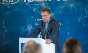 Mężczyzna w garniturze przemawia na konferencji. Dowiadujemy się, ctf co to jest, dzięki jego prezentacji.