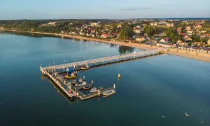 Molo w Mechelinkach z łodziami i plażą. To idealne miejsce na spacer i podziwianie widoków, jedna z głównych atrakcji Mechelinki.