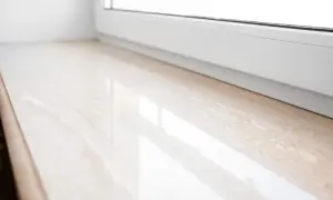 Eleganckie parapety wewnętrzne z konglomeratu w jasnym odcieniu, z subtelnym wzorem, idealnie komponują się z białym oknem.