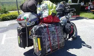 Motocykl z bagażami, gotowy na wyprawę. Widać walizki, torby i kask. To wszystko, co zabrać na wyprawę motocyklową.