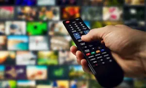 Dłoń trzymająca pilot do telewizora LG, gotowa do nauki jak zainstalować aplikacje na TV LG. Tło to mozaika ekranów.