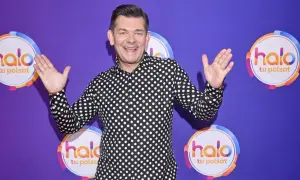 Zenek Martyniuk w czarno-białej koszuli w grochy, z podniesionymi rękami, na tle fioletowym z logo "halo tu Polsat".