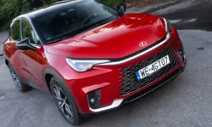 Czerwony Lexus LBX na drodze. Wiele osób szuka Lexus LBX opinie, by dowiedzieć się więcej o tym modelu.