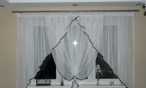 Eleganckie białe firanki z brązową lamówką, idealnie pasujące na karnisz 2m. Na parapecie zegar i wazon z kwiatami.