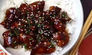 Kyckling i glansig teriyakisås med sesamfrön och gräslök, serverad över ris. Ett enkelt teriyakisås recept att prova.