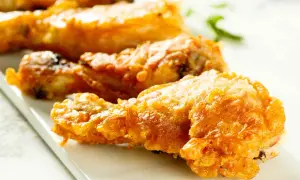 Muslos de pollo crujientes y dorados, recién salidos de la freidora de aire. Perfectos para una comida rápida y deliciosa.